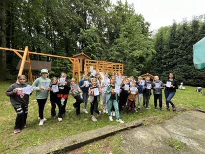 klasa 4 w raz z wychowawcą trzyma dyplomy z okazji zakończenia projektu o przyjaźni.
