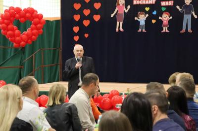 Dyrektor przemawia stojąc przed sceną.