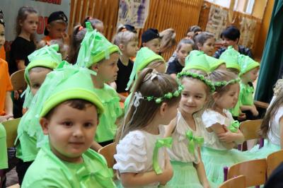 Dzieci siedzą na krzesełkach w rzędach