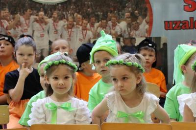 Dzieci siedzą na krzesełkach w rzędach