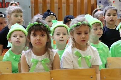 Dzieci siedzą na krzesełkach w rzędach