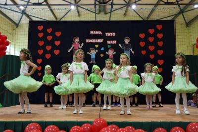 Grupka dzieci w zielonych strojach występuje na scenie