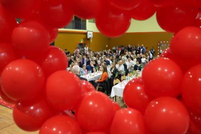 Serce z balonów i zaproszeni goście w hali sportowej