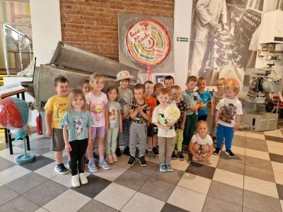 Gr.Leśne Duszki. W tle duży lizak z napisem-Poczuj się jak dziecko.