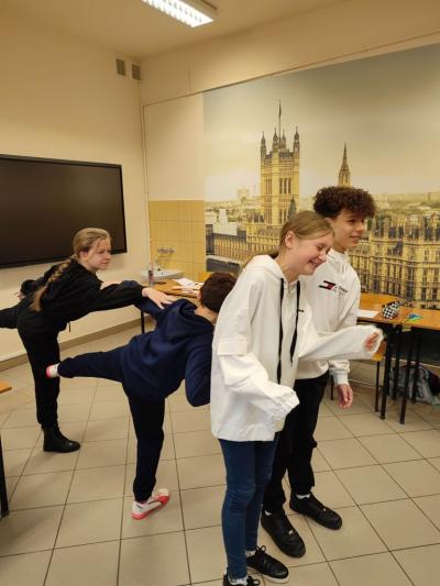 Grupa uczniów demonstrująca przedmiot swoim ciałem