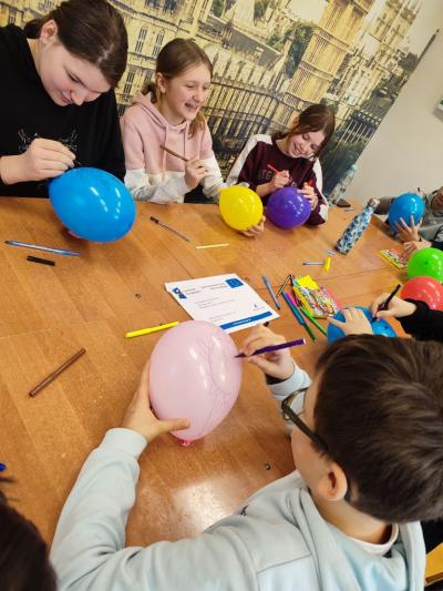Uczniowie wykonują zadanie z balonami