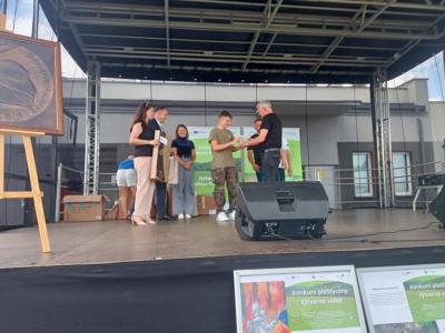 uczeń odbiera gratulację od przedstawicieli związku Gmin Dorzecza Wisłoki i zaproszonych gości, w tym od przedstawicielki Gminy Biecz