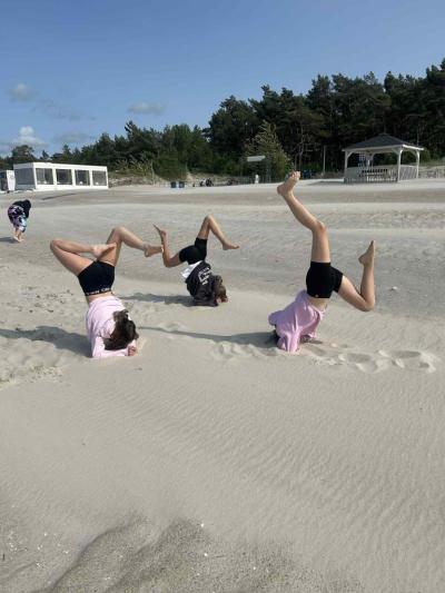 Uczennice robią figury akrobatyczna na plaży