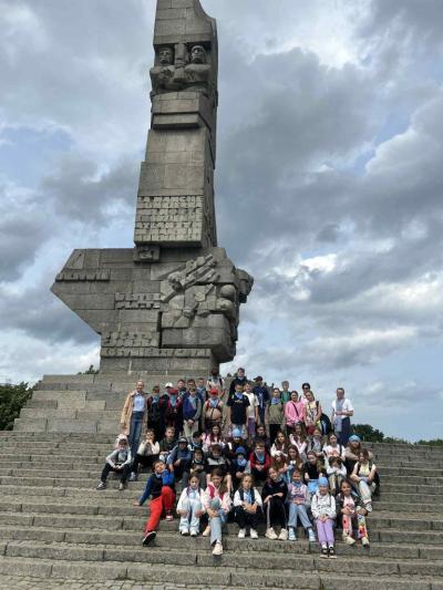 Uczniowie siedzą pod pomnikiem Westerpaltte