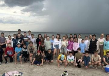 Uczestnicy Zielonej Szkoły pozują do zdjęcia na plaży. Uczestnicy Zielonej Szkoły pozują do zdjęcia na plaży.