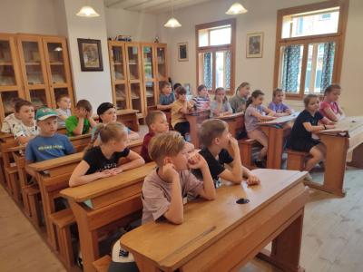 Uczniowie siedzą w ławkach w szkole w Żarnowcu w czasie warsztatów kaligrafii.v