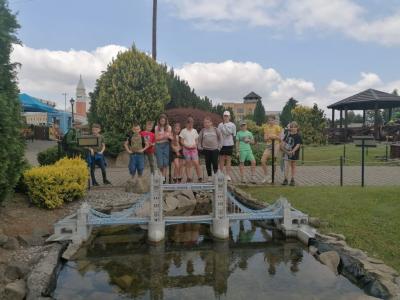 uczniowie stoją na tle budowli w parku miniatur w Inwałdzie