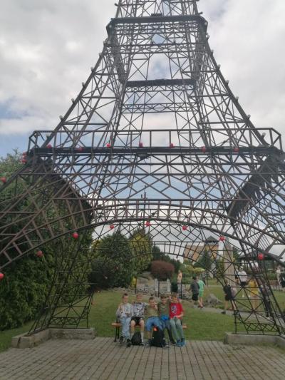 uczniowie  stoją na tle miniatury wieży Eiffla