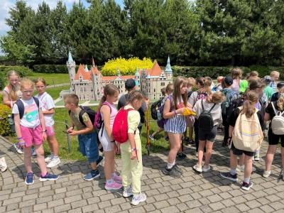 uczniowie klas 4 stoją na tle budowli w parku miniatur