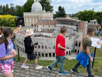 uczniowie stoją na tle budowli w parku miniatur w Inwałdzie