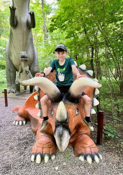 uczeń siedzi na dinozaurze