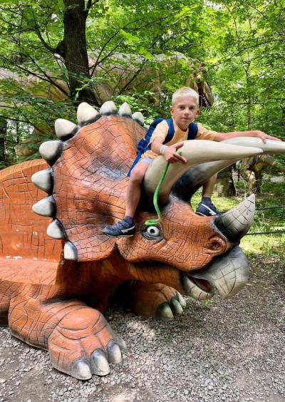 uczniowie siedzą na dinozaurze