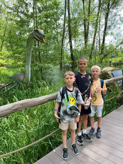 dzieci pozują na tle dinozaura