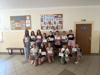 uczniowie z projektu Aktywne przerwy stoją na korytarzu wraz z koordynatorką projektu