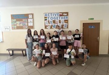 uczniowie z projektu Aktywne przerwy stoją na korytarzu wraz z koordynatorką projektu