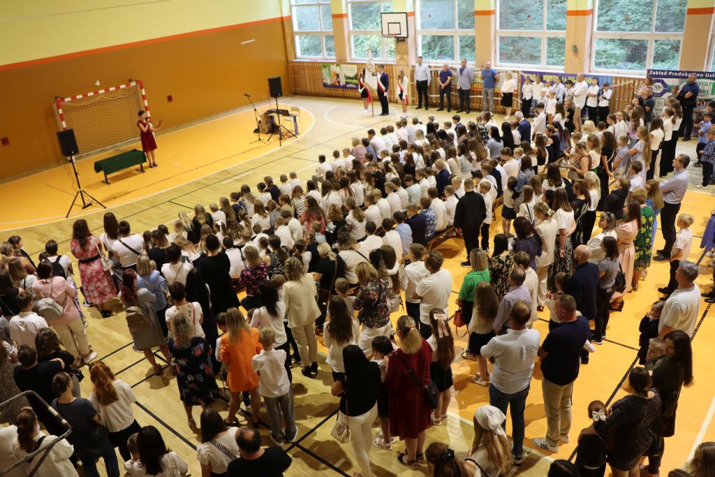 Sala gimnastyczna wypełniona uczestnikami uroczystości rozpoczęcia roku szkolnego. Sala gimnastyczna wypełniona uczestnikami uroczystości rozpoczęcia roku szkolnego.