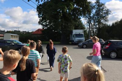 Nauczyciel prowadzi grupę uczniów na lekcję w terenie.