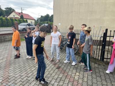 uczeń z 4a skacze w klasy ,uczy się czasownika to be, reszta dzieci patrzy