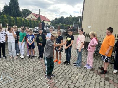 uczeń z 4a skacze w klasy ,uczy się czasownika to be, reszta dzieci patrzy
