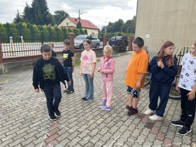 uczeń z 4a skacze w klasy ,uczy się czasownika to be, reszta dzieci patrzy