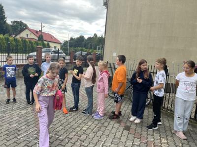 uczennica z 4a skacze w klasy i uczy się czasownika to be, reszta dzieci patrzy