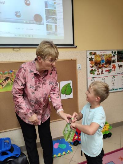 Igor wręcza mały prezent swojej babci,jtóra czytała dzieciom opowiadanie.