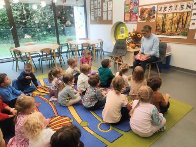 Pani Basia czyta opowiadanie. Przed nią siedzą dzieci na dywanie.