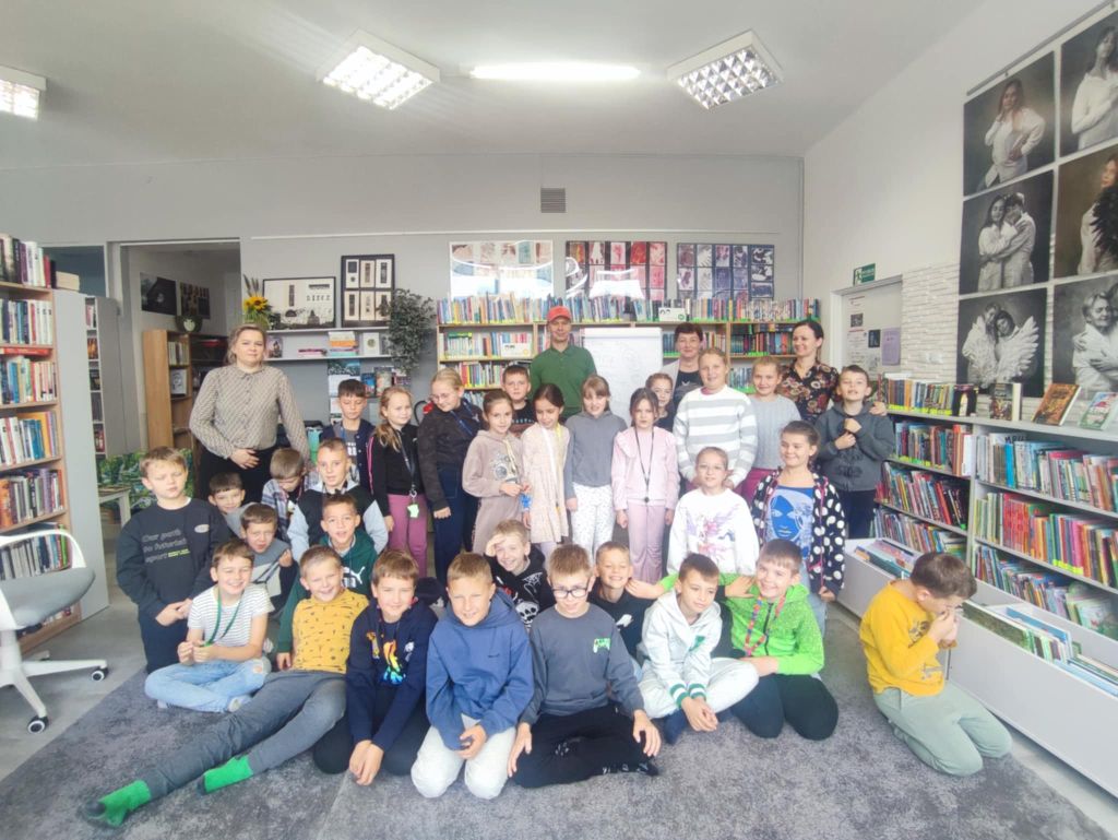 Grupka dzieci z czórką osób dorosłych pozują do zdjęcia.