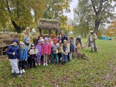 Grupa przedszkolaków stoi przed farmą dyni