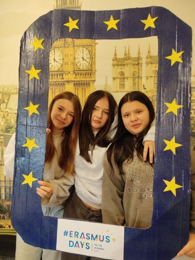 Uczennice klasy 8 pozują do zdjęcia  z ramką Erasmus