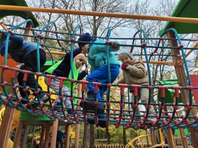 Czworo dzieci przechodzi po linach na placu zabaw w parku