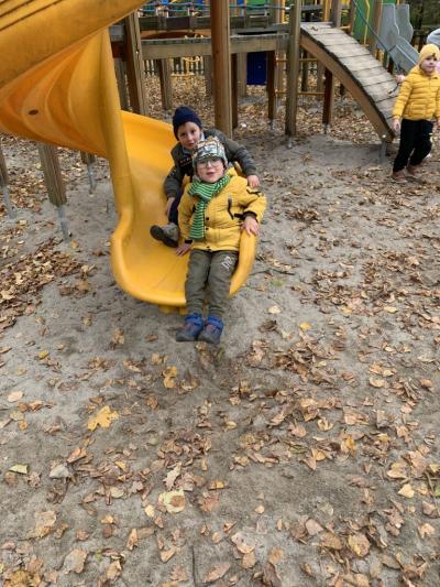 Dwóch chłopców zjeżdza żółtym tunelem.