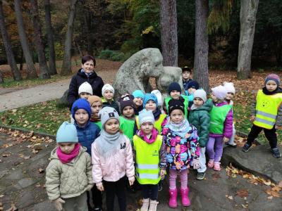 Dzieci z gr. Biedronki stoją wraz z wychowawczynią w gromadce przy pomniku misiów wyrzeźbionych w skale..jpg