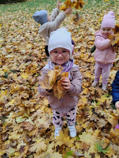 Dziewczyka pozuje z bukietem lisci