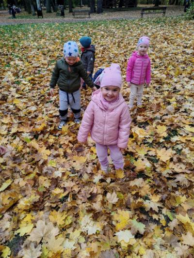 Dziewczynka stoi wśród lisci