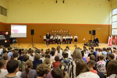 W odali uczniowie występujący podczas akademii, na pierwszym planie widownia.