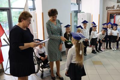 Dyrektor szkoły pani Agnieszka Kapusta pasuje ołówkiem ucznia