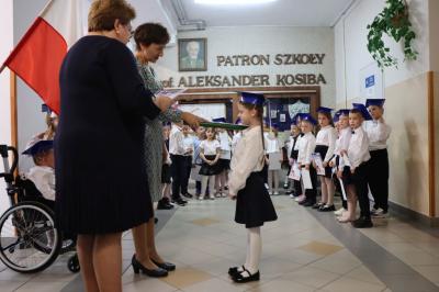 Dyrektor szkoły pani Agnieszka Kapusta pasuje ołówkiem ucznia