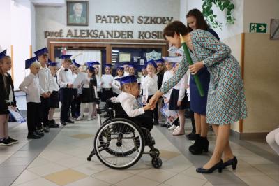Dyrektor szkoły pani Agnieszka Kapusta pasuje ołówkiem ucznia