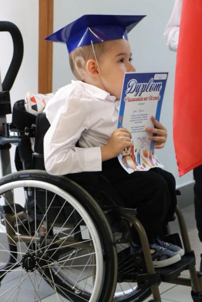 Występujący w pasowaniu uczeń siedzący na wózku inwalidzkim