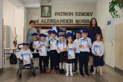 Uczniowie pozują do zdjęcia grupowego wraz z panią dyrektor i wychowawczynią