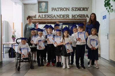 Uczniowie pozują do zdjęcia grupowego wraz z panią dyrektor i wychowawczynią