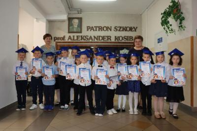 Uczniowie pozują do zdjęcia grupowego wraz z panią dyrektor i wychowawczynią