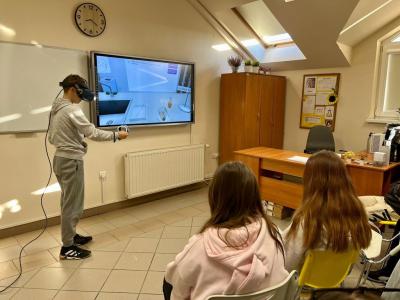 uczeń wykonuje doświadczenie korzystając z gogli VR i kontrolerów