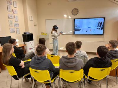 uczniowie obserwują koleżankę wykonującą doświadczenie z wykorzystaniem Empiriusza